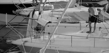 İtalya, Sicilya, Akdeniz, Marina di Ragusa (Ragusa ili); 30 Ağustos 2025; limanda lüks bir yatı temizleyen adam - EDITORIAL