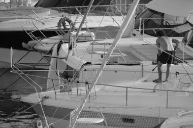 İtalya, Sicilya, Akdeniz, Marina di Ragusa (Ragusa ili); 30 Ağustos 2025; limanda lüks bir yatı temizleyen adam - EDITORIAL