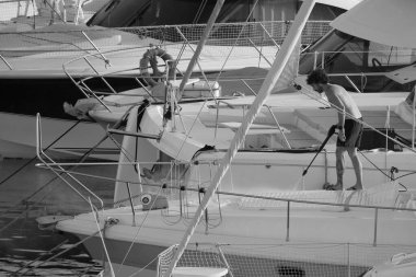 İtalya, Sicilya, Akdeniz, Marina di Ragusa (Ragusa ili); 30 Ağustos 2025; limanda lüks bir yatı temizleyen adam - EDITORIAL