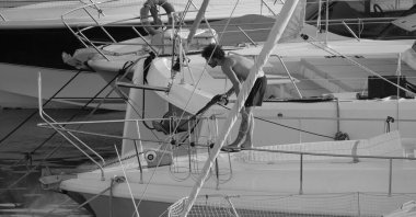 İtalya, Sicilya, Akdeniz, Marina di Ragusa (Ragusa ili); 30 Ağustos 2025; limanda lüks bir yatı temizleyen adam - EDITORIAL