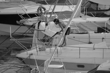 İtalya, Sicilya, Akdeniz, Marina di Ragusa (Ragusa ili); 30 Ağustos 2025; limanda lüks bir yatı temizleyen adam - EDITORIAL