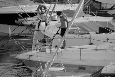 İtalya, Sicilya, Akdeniz, Marina di Ragusa (Ragusa ili); 30 Ağustos 2025; limanda lüks bir yatı temizleyen adam - EDITORIAL