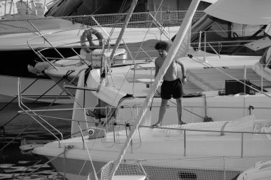 İtalya, Sicilya, Akdeniz, Marina di Ragusa (Ragusa ili); 30 Ağustos 2025; limanda lüks bir yatı temizleyen adam - EDITORIAL