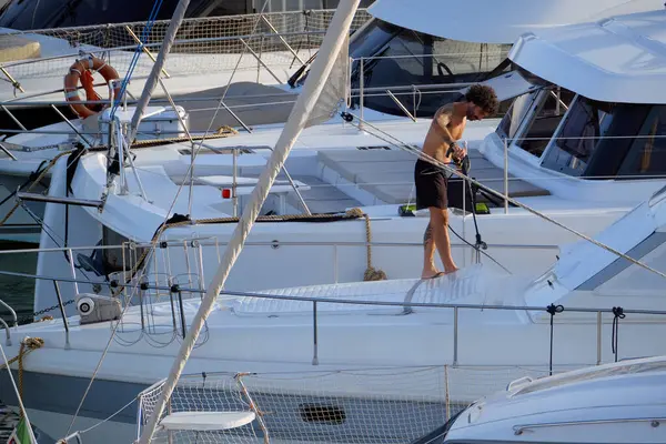 İtalya, Sicilya, Akdeniz, Marina di Ragusa (Ragusa ili); 30 Ağustos 2025; limanda lüks bir yatı temizleyen adam - EDITORIAL