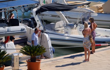 İtalya, Sicilya, Akdeniz, Marina di Ragusa (Ragusa ili); 31 Ağustos 2025, limandaki bir katamaran yelkenli teknesinde insanlar - EDITORIAL