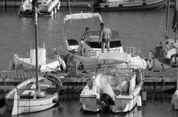 İtalya, Sicilya, Akdeniz, Marina di Ragusa (Ragusa Eyaleti); 1 Eylül 2025, limanda büyük bir kauçuk teknede erkekler - EDITORIAL