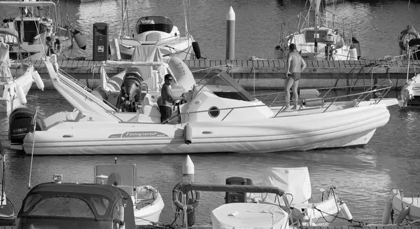 İtalya, Sicilya, Akdeniz, Marina di Ragusa (Ragusa Eyaleti); 1 Eylül 2025, limanda büyük bir kauçuk teknede erkekler - EDITORIAL