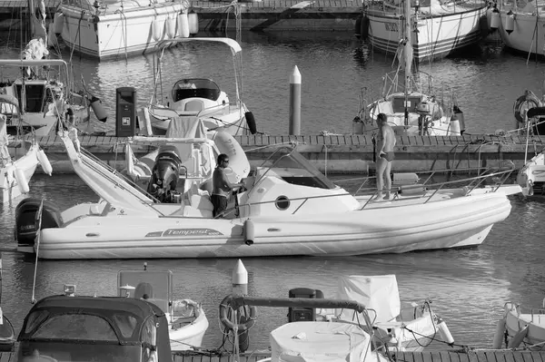 İtalya, Sicilya, Akdeniz, Marina di Ragusa (Ragusa Eyaleti); 1 Eylül 2025, limanda büyük bir kauçuk teknede erkekler - EDITORIAL