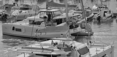 İtalya, Sicilya, Akdeniz, Marina di Ragusa (Ragusa Eyaleti); 26 Eylül 2025, limanda bir katamaran yelkenli teknesinde çift - EDITORIAL