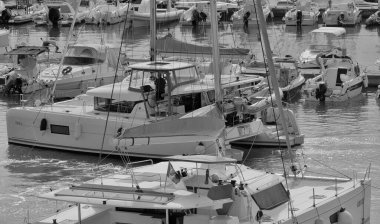 İtalya, Sicilya, Akdeniz, Marina di Ragusa (Ragusa Eyaleti); 26 Eylül 2025, limanda bir katamaran yelkenli teknesinde çift - EDITORIAL