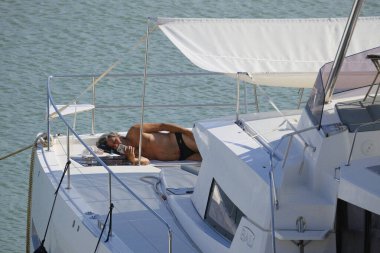 İtalya, Sicilya, Akdeniz, Marina di Ragusa (Ragusa Eyaleti); 28 Eylül 2025, limandaki bir katamaran motorlu teknesinde adam - EDITORIAL