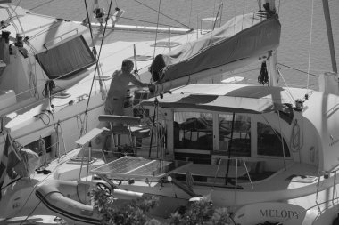 İtalya, Sicilya, Akdeniz, Marina di Ragusa (Ragusa Eyaleti); 29 Eylül 2025, limandaki bir katamaran yelkenli teknesinde adam - EDITORIAL