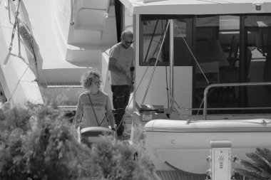 İtalya, Sicilya, Akdeniz, Marina di Ragusa (Ragusa Eyaleti); 30 Eylül 2025, limandaki katamaran yelkenli teknesinde insanlar - EDITORIAL