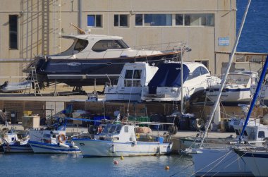 İtalya, Sicilya, Marina di Ragusa (Ragusa Eyaleti); 30 Eylül 2025, limanda yerel balıkçı tekneleri ve lüks yatlar - EDITORIAL