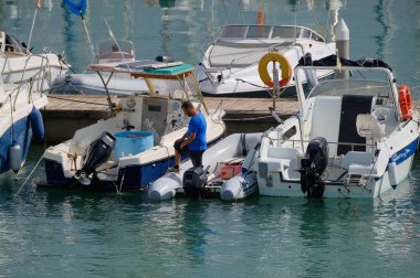 İtalya, Sicilya, Akdeniz, Marina di Ragusa (Ragusa Eyaleti); 1 Ekim 2025, limanda bir kauçuk teknede adam - EDITORIAL