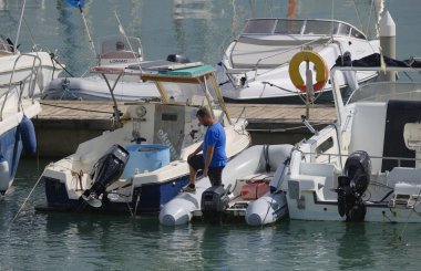 İtalya, Sicilya, Akdeniz, Marina di Ragusa (Ragusa Eyaleti); 1 Ekim 2025, limanda bir kauçuk teknede adam - EDITORIAL