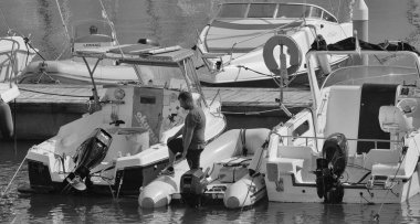 İtalya, Sicilya, Akdeniz, Marina di Ragusa (Ragusa Eyaleti); 1 Ekim 2025, limanda bir kauçuk teknede adam - EDITORIAL