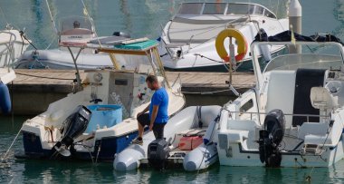 İtalya, Sicilya, Akdeniz, Marina di Ragusa (Ragusa Eyaleti); 1 Ekim 2025, limanda bir kauçuk teknede adam - EDITORIAL