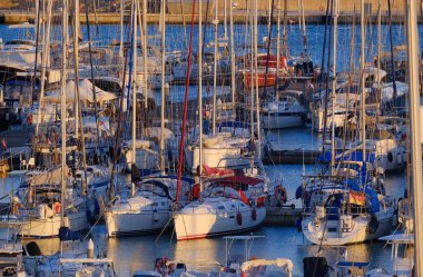 İtalya, Sicilya, Akdeniz, Marina di Ragusa (Ragusa ili); 2 Ekim 2025, gün batımında limanda motorlu tekne ve lüks yatlar - EDITORIAL