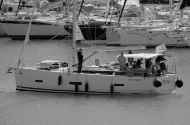 İtalya, Sicilya, Akdeniz, Marina di Ragusa (Ragusa Eyaleti); 3 Ekim 2025, limandaki bir yelkenli ve lüks yatlarda yaşayan insanlar - EDITORIAL