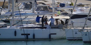 İtalya, Sicilya, Akdeniz, Marina di Ragusa (Ragusa Eyaleti); 3 Ekim 2025, limandaki bir yelkenli ve lüks yatlarda yaşayan insanlar - EDITORIAL