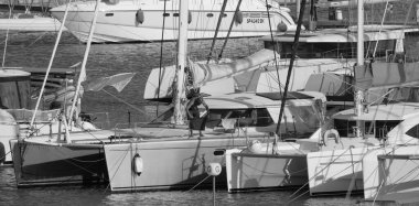 İtalya, Sicilya, Akdeniz, Marina di Ragusa (Ragusa Eyaleti); 4 Ekim 2025, limandaki bir katamaran yelkenli teknesinde adam - EDITORIAL