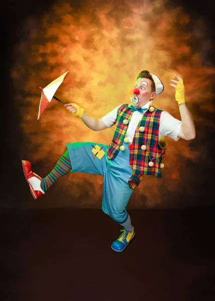一个有趣的小丑与微笑的喜悦的表情 在有色的背景 — 图库照片