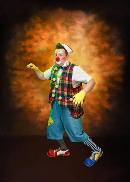 一个有趣的小丑与微笑的喜悦的表情 在有色的背景 — 图库照片