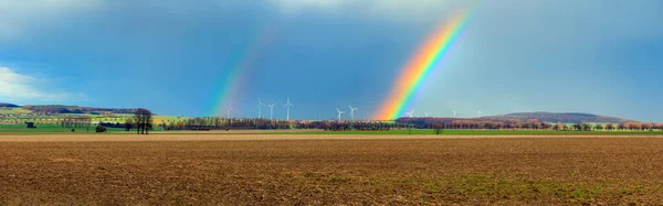 ドイツの村を背景に耕された畑の上の虹 — ストック写真
