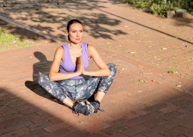 Açık havada egzersiz yapan zinde bir kadın. Sağlıklı genç bayan sporcu spor yapıyor. Spor kıyafetli bir kadın.