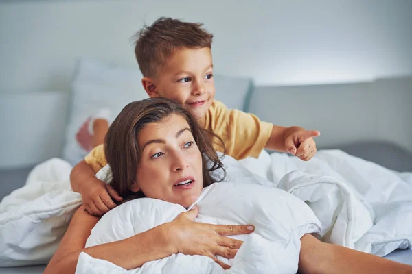 年轻的母亲和4岁的儿子在床上 高质量的照片 — 图库照片