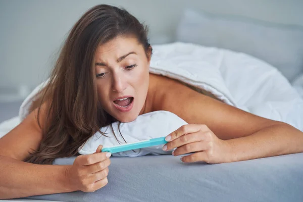 Yatağında Hamilelik Testi Olan Esmer Bir Kadın Yüksek Kalite Fotoğraf — Stok fotoğraf