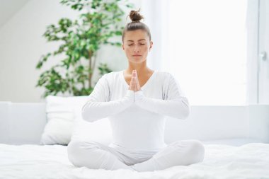 Yatakta dinlenen ya da yoga yapan hoş bir kadın. Yüksek kalite fotoğraf