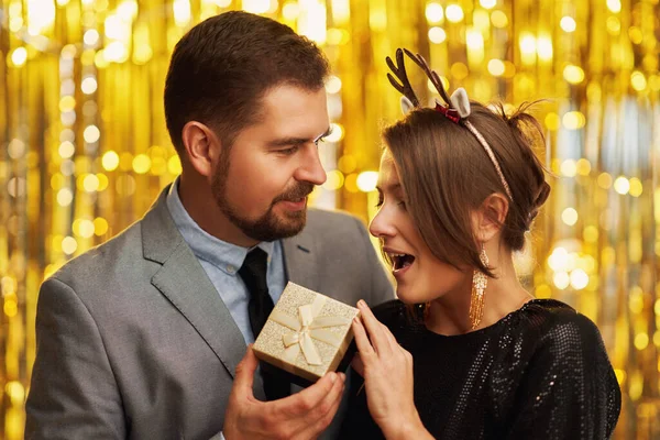 新年やクリスマスパーティーに金の贈り物を持つカップル 高品質の写真 — ストック写真