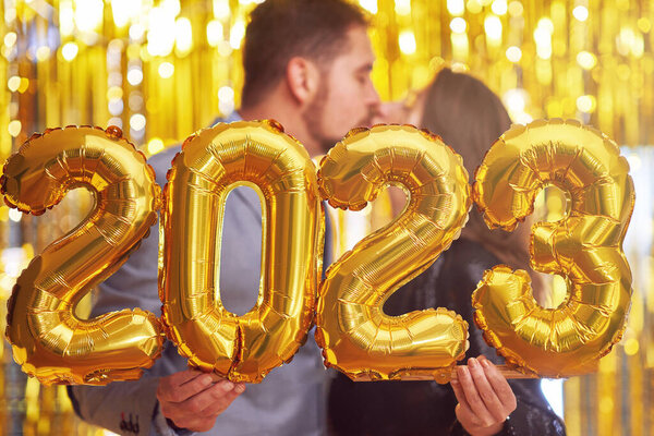 Couple at new year eve party with gold balloons. High quality photo
