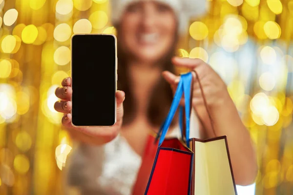 Junge Frau Mit Einkaufstaschen Über Goldenem Hintergrund Die Ihr Handy — Stockfoto