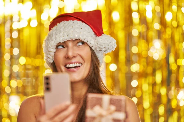 Donna Sfondo Oro Cappello Babbo Natale Con Telefono Foto Alta — Foto Stock