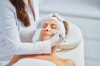 Woman having permanent eyebrows cosmetology treatment. High quality photo