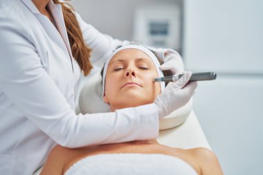 Woman in a beauty salon having needle mesotherapy treatment. High quality photo