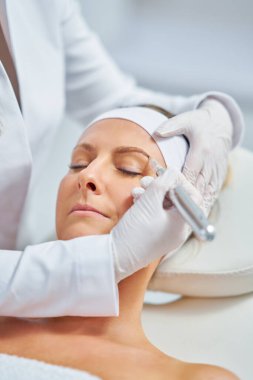 Woman having permanent eyebrows cosmetology treatment. High quality photo