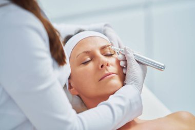 Woman having permanent eyebrows cosmetology treatment. High quality photo