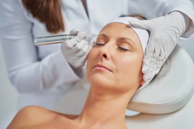 Woman having permanent eyebrows cosmetology treatment. High quality photo