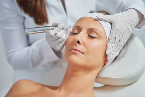 Woman having permanent eyebrows cosmetology treatment. High quality photo
