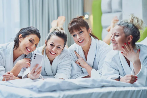 Girls at spa party in hotel with phone. High quality photo