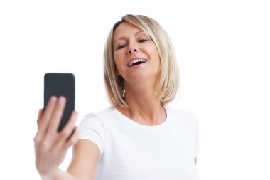 Picture of blonde woman over back isolated background with mobile phone. High quality photo