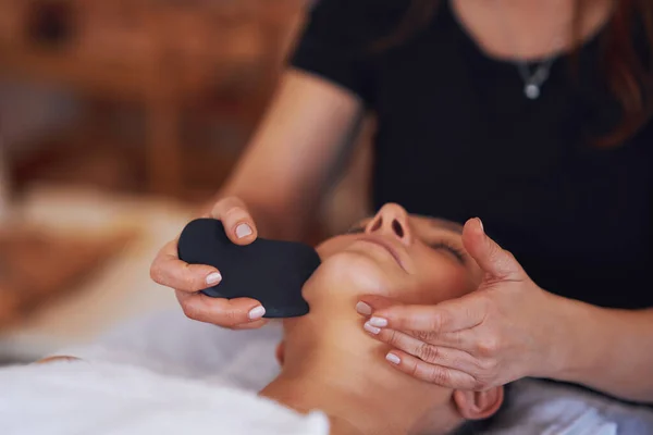 Brunette Vrouw Met Een Stenen Massage Haar Gezicht Hoge Kwaliteit — Stockfoto