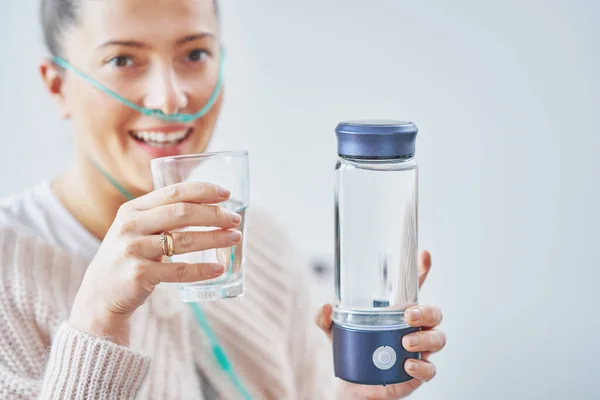 Picture of woman having hydrogen water in hand. High quality photo