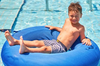 Aquapark 'ta tüpte eğlenen küçük bir çocuğun resmi. Yüksek kalite fotoğraf