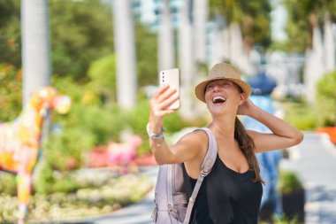 Miami 'den, parkta selfie çeken bir kadının fotoğrafı. Yüksek kalite fotoğraf