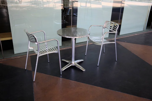 table and Chairs. Patio Furniture. Aluminum Chairs  and table   on a Patio.